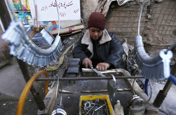 A boy makes keys on a roadside on the eve of International Children's Day, in Peshawar, Pakistan. This year the theme of the day will concentrate on banning corporal punishment of children.