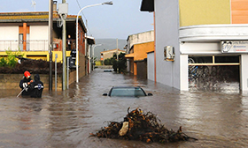 Rescuers work in a flooded street in the small town of Uras, Sardinia
