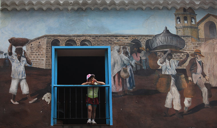 Your Pictures - Snack: boy snacking in doorway of mural building