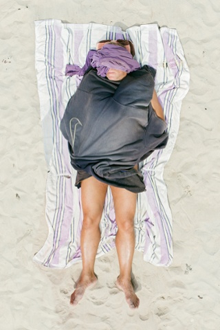 Um banhista relaxado coberto em uma praia na Lituânia.