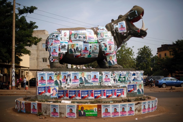 Uma estátua de um hipopótamo é coberta com cartazes eleitorais a uma rotunda em Bamako, Mali.