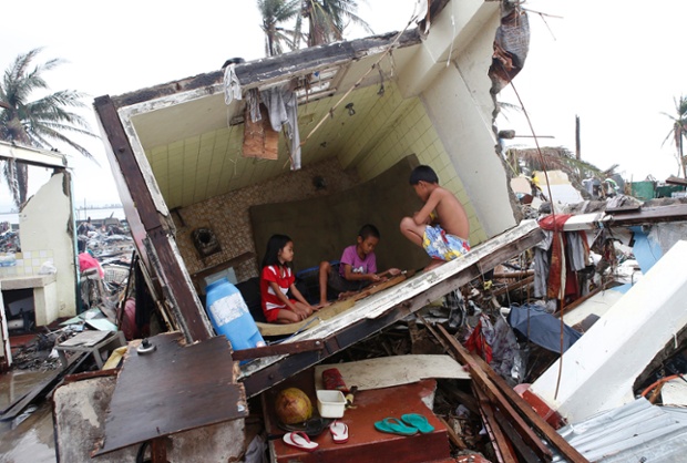 Children play a game inside the bathroom of a house in Tacloban almost two weeks after Typhoon Haiyan hit the central Philippines.