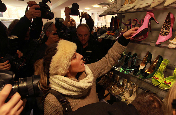 Beckhams' clothes sale: Photographers take pictures of a woman looking at shoes