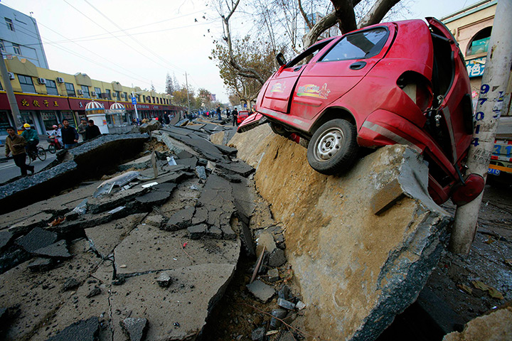 Weekend in pictures : Huangdao, China: A car perches on a damaged road after an explosion in a Si
