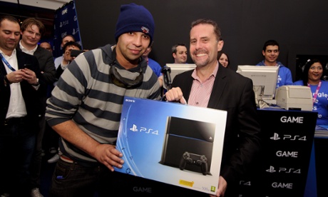 Andrew House, right, hands over the first PS4 to Imran Chowdri.