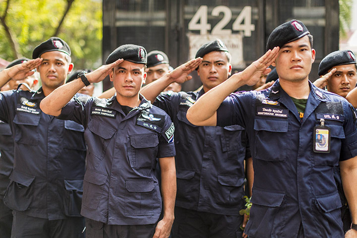 Thailand protests: Thai police officers salute as protesters sing the King's Anthem