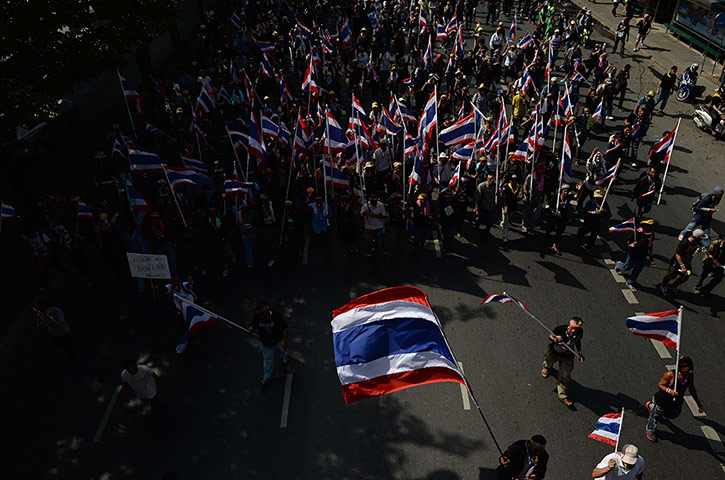 Thailand protests: Protesters wave national flags as they march towards a government complex