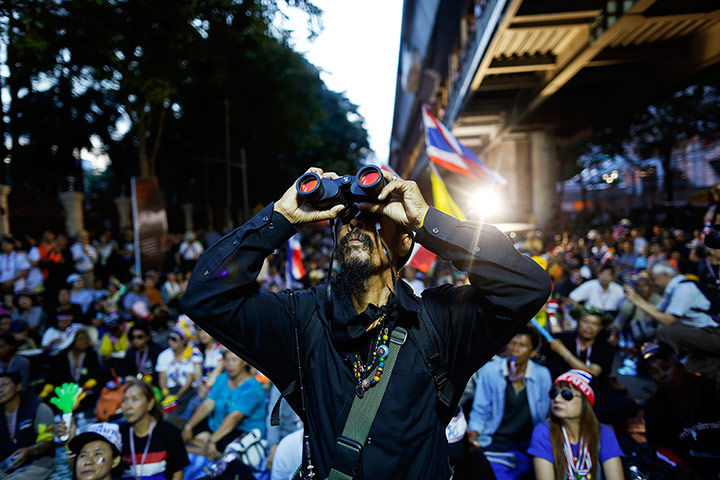 Thailand protests: Protester uses binoculars to look at the national police headquarters