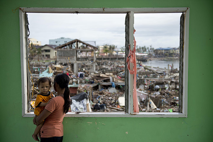 20 Photos: A victim from super typhoon Haiyan holds her daughter in Tacloban