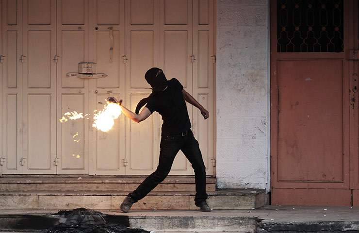 20 Photos: A masked Palestinian protester throws a Molotov cocktail in Hebron