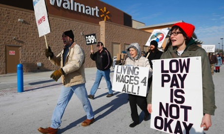 A group of protesters walk through the Walmart retail store parking lot on Black Friday in Elgin, Illinois, November 29, 2013.