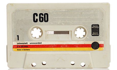 Vintage compact cassette audio tape on white with natural reflection.