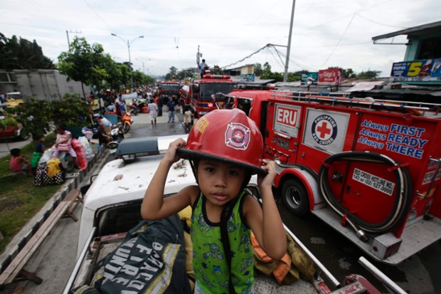 This three year old is the son of a fire volunteer who has been called to an emergency in a residential area in Culiat district, Quezon City in the Philippines.