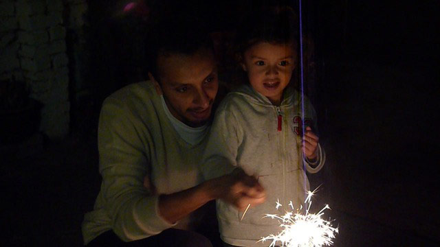 GW-Diwali: Boy holds sparkler, helped by father