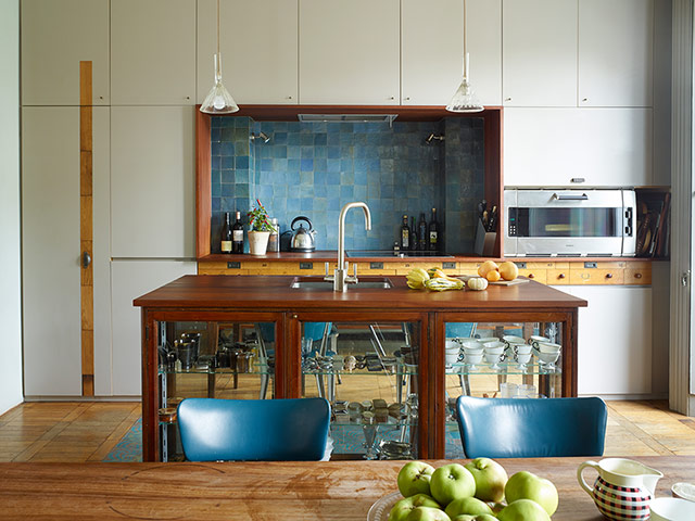 Homes - In With The Old: kitchen area with blue chairs and white cupboards