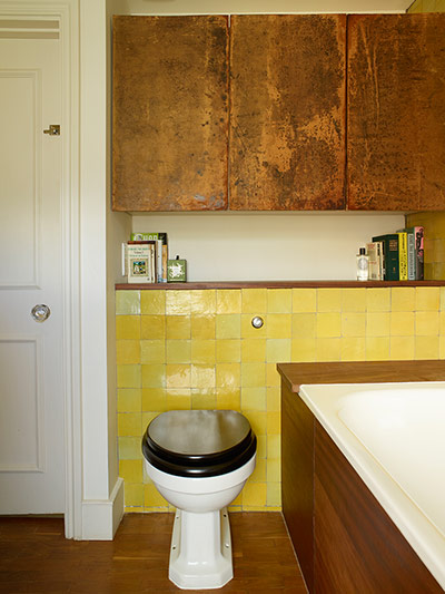 Homes - In With The Old: bathroom with yellow tiling and copper cabinets
