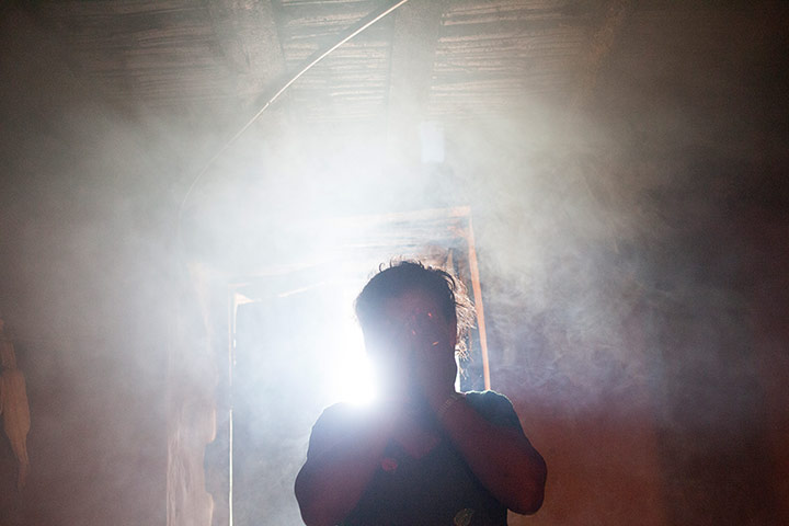 International Journalism: Woman covering face engulfed in smoke in her kitchen