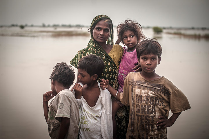 International Journalism: Indian mother and her children standing by a river