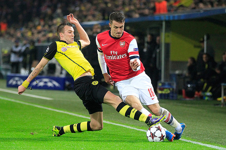 champions league: Kevin Grosskreutz, left, challenges Aaron Ramsey