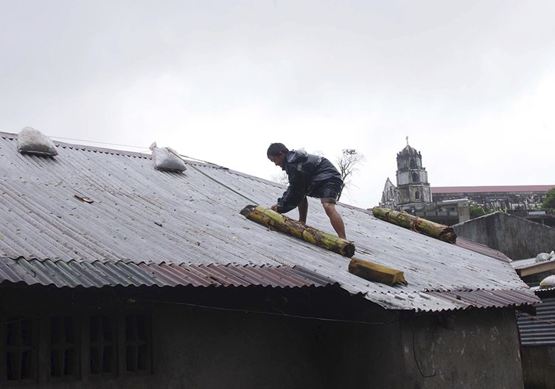 A man reinforces his house with banana stalks