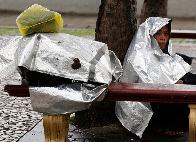 Typhoon: A Filipino woman uses a plastic sheet during a downpour brought by Typhoon 