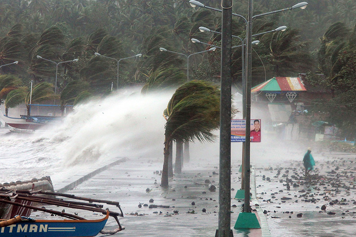 Typhoon update: A resident walks past high waves pounding the sea wall amidst strong winds 