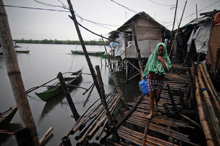 Typhoon update: A resident walks along a fishing village in Bacoor