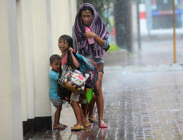 Typhoon update: A mother takes refuge with her children as Typhoon Haiyan hits Cebu city