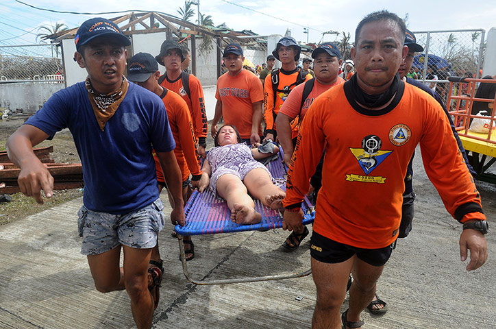 Typhoon Haiyan: Rescue workers carry a woman a