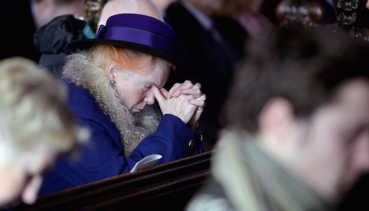 glasgow crash memorial: A member of the public prays in Glasgow Cathedral