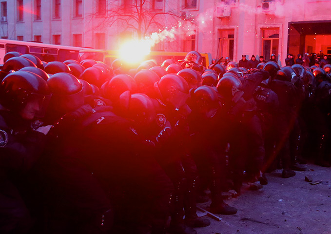 Ukraine protests: A flare thrown by protesters lands on riot police 