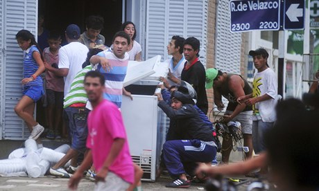 People carry equipment from a looted shop in the northern Argentinian province of Tucuman