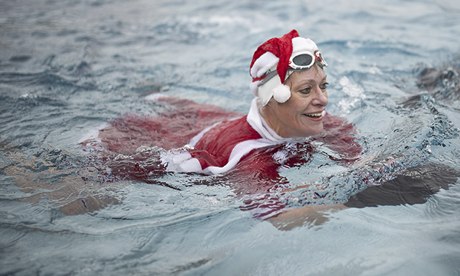 Woman swimming dressed as Santa