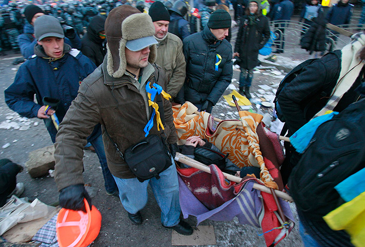 Ukraine protests: Pro-European integration protesters carry an injured man 