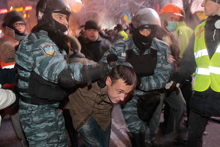 Ukraine protests: Ukrainian riot policemen pull a Pro-European Union activist out form a tent