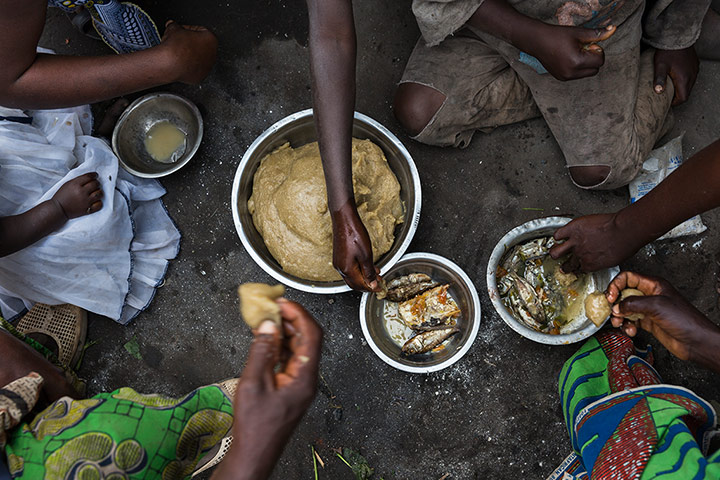 WWF Virunga Campaign: Local village family eating a meal of Fou Fou Kasava and fish 