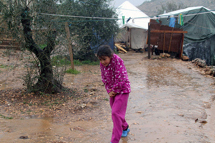 Winter in Syria: A Syrian refugee girl walks near her tent in a camp in Ketermaya, Lebanon. 