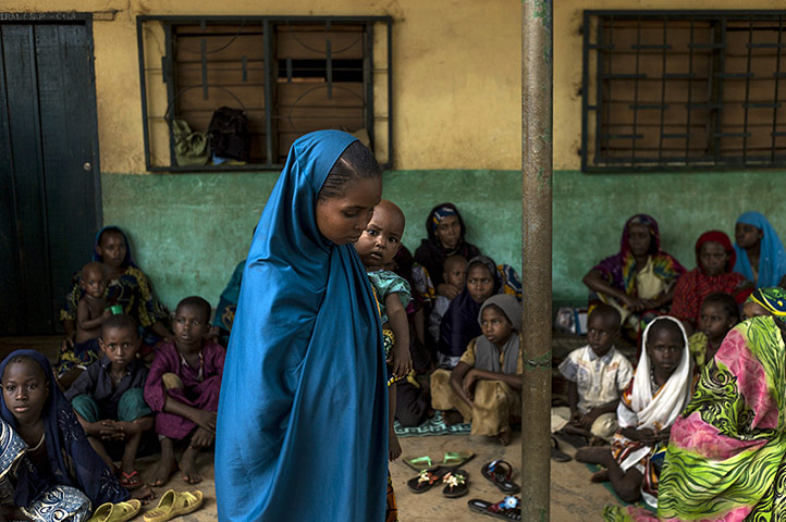 20 Photos: a young woman holds her baby at a school in Bangui