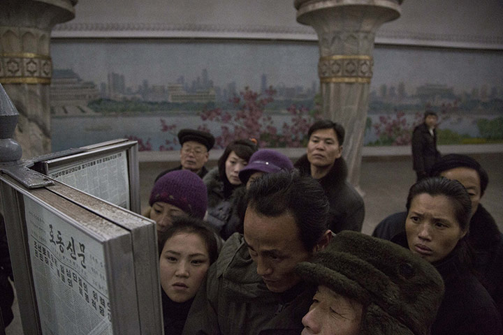 20 Photos: North Korean commuters gather around a newspaper stand