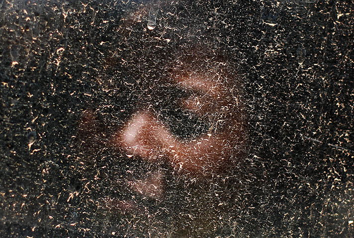 20 Photos: a woman looks out of a dusty window after boarding a bus in South AFrica