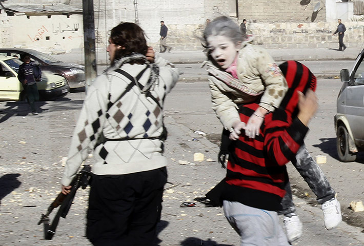 20 Photos: a man carries a wounded girl in Aleppo