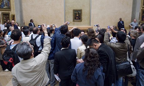 Tourists photographing the Mona Lisa in the Louvre in Paris
