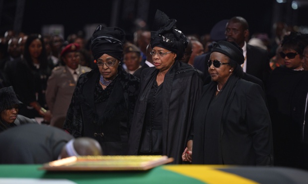 Winnie Madikizela-Mandela and Mandela's widow, Graca Machel, stand by his coffin.
