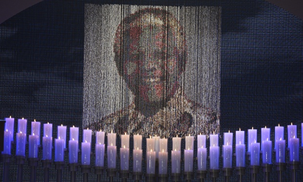 Candles are lit under a portrait of Neslon Mandela before the ceremony