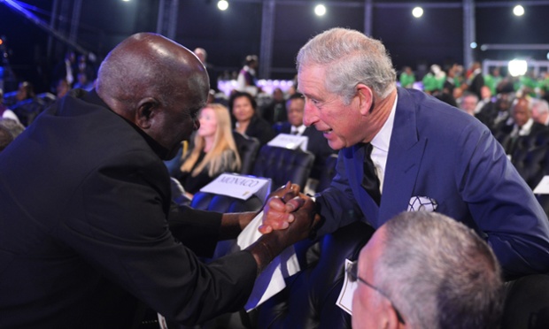 Prince Charles is greeted by another mourner as he arrives.