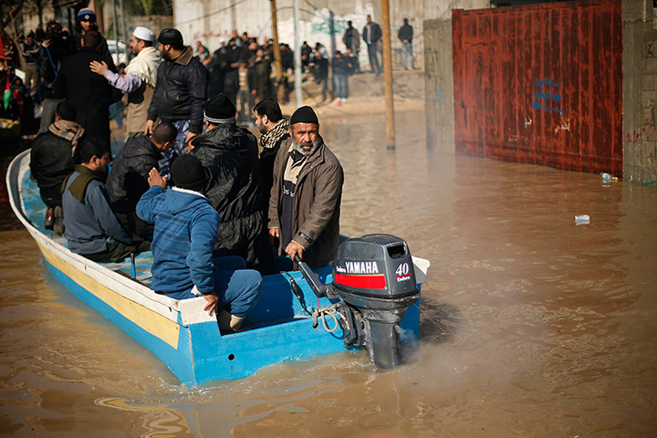 Weekend in pictures: Gaza Strip, Gaza: Residents travel on a boat after their houses were floode