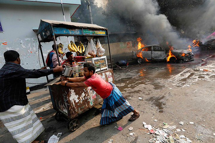Weekend in pictures: Dhaka, Bangladesh: Street vendors move their pushcart stalls away after veh