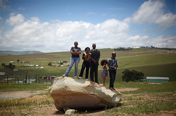 Weekend in pictures: Qunu, South Africa: A group of people stand on a rock overlooking the funer