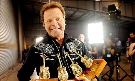 Troy Cassar-Daley holds his Golden Guitar awards