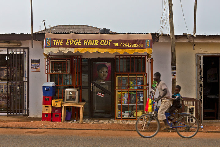 big picture - barbers: two people on a bicycle outside a barber shop